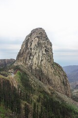 Fototapeta premium Majestic rock formation towering above greenery, a sight for nature enthusiasts and adventure seekers, creating a mesmerizing landscape.