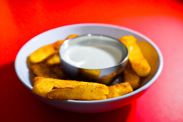 Deep fried cassava root with with sauce in red background