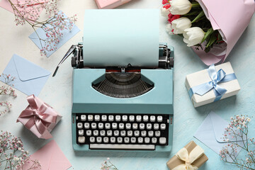 Typewriter, flowers and gift boxes for Women's Day on light blue background