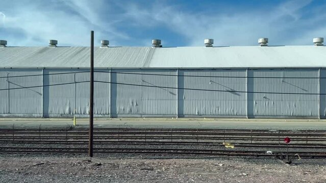 Video panning along warehouses in an industrial park, located along the train tracks in the San Joaquin Valley of California.