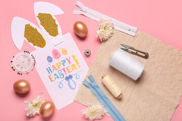 Composition with greeting card, sewing supplies and Easter decor on pink background