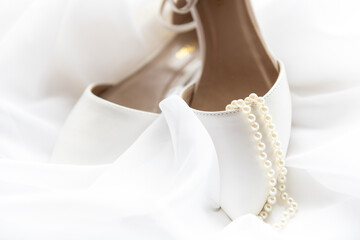 White wedding shoes and pearls