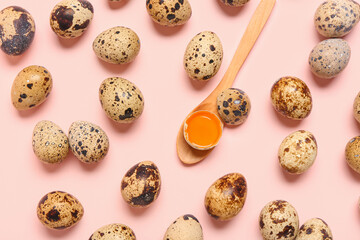 Fresh quail eggs and wooden spoon on pink background