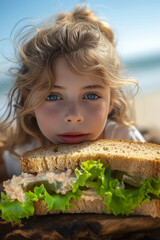 girl eating a sandwich on the beach