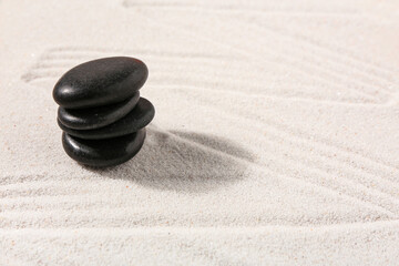Fototapeta na wymiar Stack of stones on sand with lines in Japanese rock garden. Zen concept