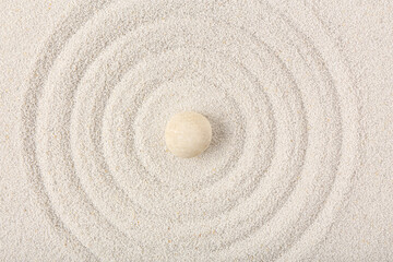 Fototapeta na wymiar Stone on sand with lines in Japanese rock garden, top view. Zen concept