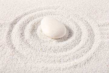Fototapeta na wymiar Stone on sand with lines in Japanese rock garden. Zen concept