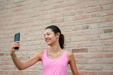 Virtual Fitness Prep: Young Woman Engaging in Video Chat Before Exercise