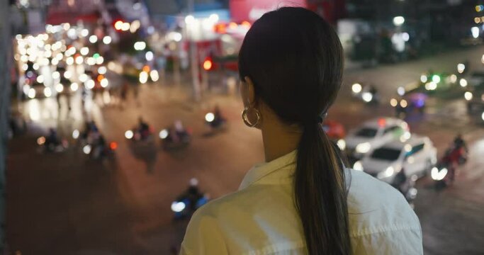Woman looking at busy evening traffic of large modern city back view close-up Crowdedness sign of modern metropolis. Crowdedness constant motion in urban life Crowdedness city never sleeps.