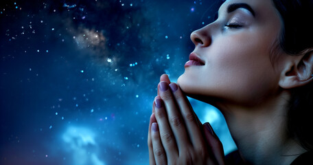 A woman praying against the backdrop of the star-filled sky.
