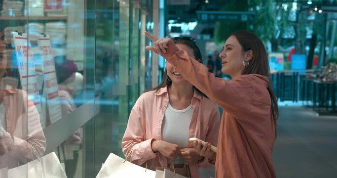 Storefronts in mall captivate women talking about buys Storefronts reveal worlds of style pleasure. Storefronts gateways to happy shopping chic apparel Celebrating fashion finds shared joy.