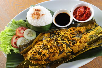 asian traditional food talapia fish  steam with spicy and turmeric wraping with  banana leaf  and...