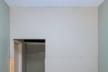 Drywall screwing plasterboard to wooden beams during renovation of home