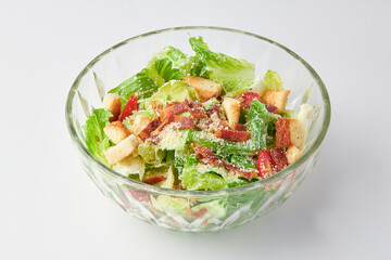 Classic Caesar salad with bacon mixed with green salad, Croutons (Crispy Bread), Crispy Bacon and Tomatoes , topped with Parmesan cheese on bowl isolated on white background. healthy food.
