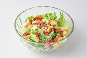 Classic Caesar salad with bacon mixed with green salad, Croutons (Crispy Bread), Crispy Bacon and Tomatoes , topped with Parmesan cheese on bowl isolated on white background. healthy food.