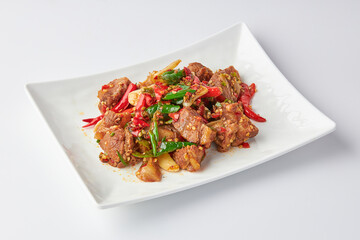 Stir-fried stewed beef shank with holy basil , chili and garlic served on white plate isolated on white background. Stir-fried holy basil is a very popular food in Thailand.