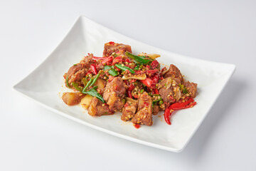 Stir-fried stewed beef shank with holy basil , chili and garlic served on white plate isolated on white background. Stir-fried holy basil is a very popular food in Thailand.
