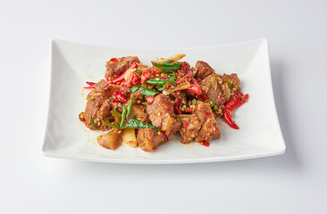Stir-fried stewed beef shank with holy basil , chili and garlic served on white plate isolated on white background. Stir-fried holy basil is a very popular food in Thailand.