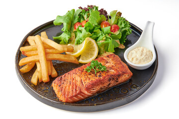 Large salmon steak served with fried french fries, fresh salad and tomatoes, creamy dipping sauce...