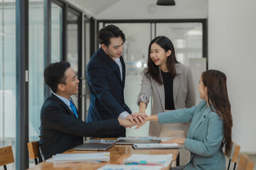 A group of employees join hands to encourage work before starting a big project assigned by an important customer of the company, Make a gesture of helping each other by joining hands together.