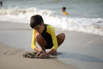 Child and person enjoying beach fun by the sea, playing and fishing in the sand on a sunny summer day - 776738213