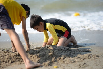 Child and person enjoying beach fun by the sea, playing and fishing in the sand on a sunny summer day - 776738273