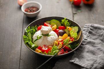 Salad with traditional italian burrata cheese. Burrata ball with cherry tomatoes, cucumber slices,...