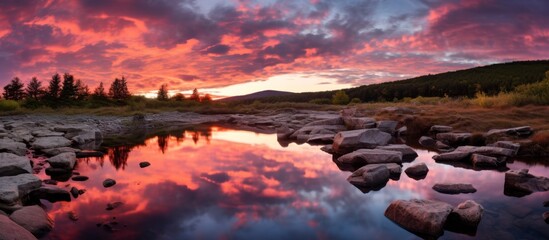 The beautiful scenery of a red sky being reflected in a calm small river during sunset, creating a serene and captivating view