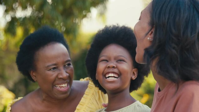 Loving three generation female family laughing and hugging outdoors in countryside together - shot in slow motion