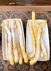 spanish dessert churros for breakfast. delicious fried sweet treat sprinkled with powdered sugar