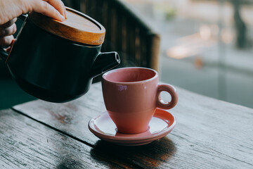 Pouring tea in a pink tea cup