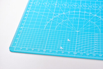 blue cutting mat board on white background with line and scale measure guide pattern for object art design, tool equipment of diy craft work