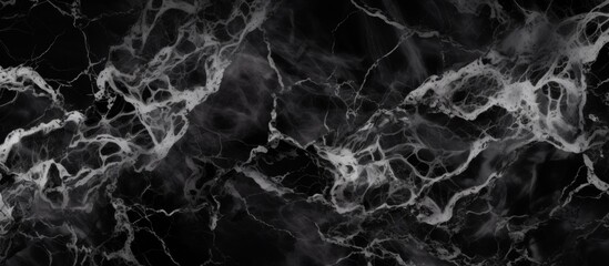 Close up of a sophisticated black marble background with elegant white veining patterns blending through the surface