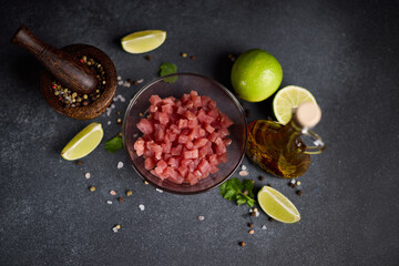Sliced and chopped tuna fillet in glass bowl at domestic kitchen cooking traditional tartare