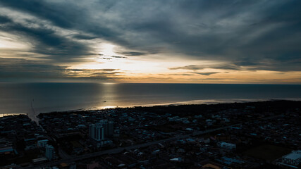 A dramatic panoramic aerial view of Sekinchan fishing town at golden sunset time.