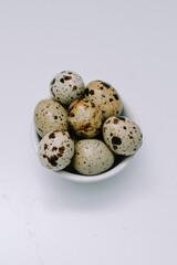 Fototapeta premium Quail eggs that are the size of an adult human's thumb are lined up on a white mat for photographic and detailed purposes.