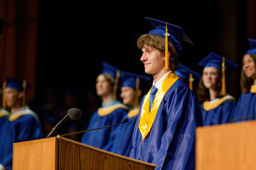 Young male student giving a speech at graduation ceremony