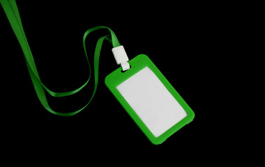 Green blank badge with string isolated on black background.	
