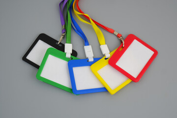 Many different blank badges with strings on gray background. 