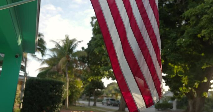 American flag wrapped around flag pole in average american neighbourhood - tilt down