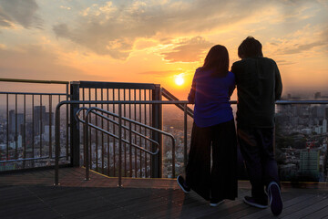Silhouette teenager lovers couple over natural background at the cityscape  and holding hands...