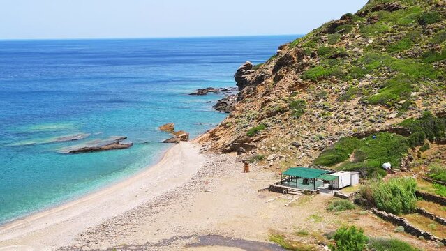 Aris beach at Karavostamo village on Ikaria island, Greece with landscape nature view by empty cafe restaurant building