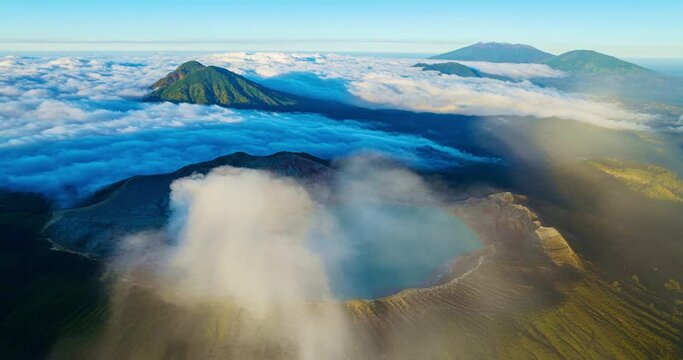 Aerial view Drone shot of fog at Kawah Ijen volcano with turquoise sulfur water lake and sunrise light.Amazing nature landscape view at East Java,Indonesia.Beautiful light Natural landscape background