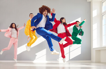 Dressed in colorful business suits group of dancers dancing and jumping in air colorful suits. Positive emotional dancers dancing happily Jumping and dancing funny positive emotion