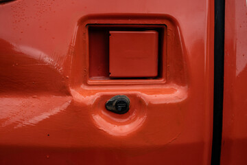 Latch of the engine cover of an orange excavator.