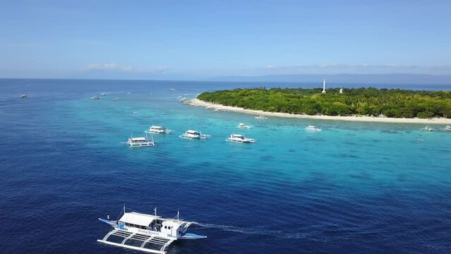 Panglao Island, Philippines - Feb 27, 2019: Aerial of Balicasag Island, surrounded by Outrigger boats.