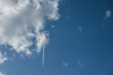 white cloud and a aircraft trail on blue sky
