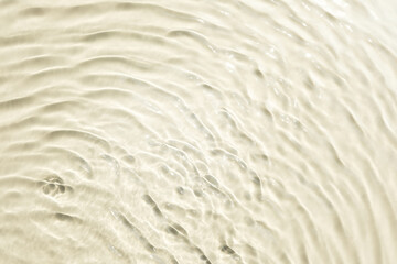 Background summer natural beige texture, clear water with ripples and splashes. Water waves in...