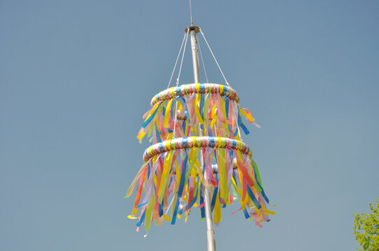 Bunte Pfingstkr&auml;nze aus Tradition zum christlichen Fest: Die farbenfrohen B&auml;ndern wehen sanft im Fr&uuml;hlingswind vor blauen Himmel.