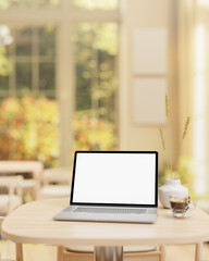 A laptop computer mockup and a coffee cup are placed on a wooden table in a beautiful coffee shop. - 776907896